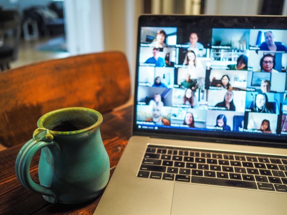 A laptop on a wooden table during a video call — staying connected across distance