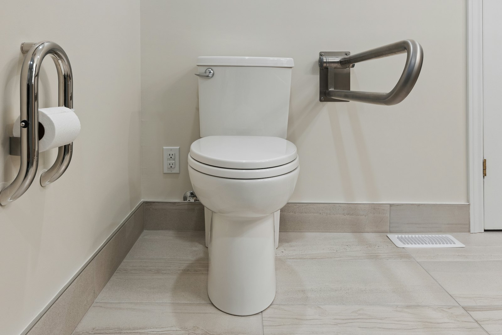 An accessible bathroom with grab bars beside the toilet.